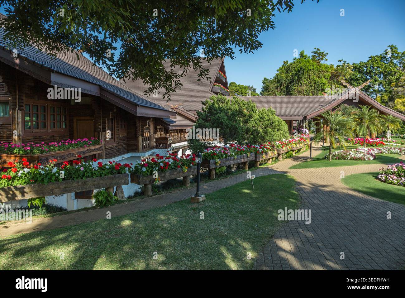 Des arbres ornés et des jardins fleuris luxuriants rehaussent l'architecture Lanna et suisse de la Villa royale Doi Tung à l'intérieur de l'attraction touristique Doi Tung à CH Banque D'Images
