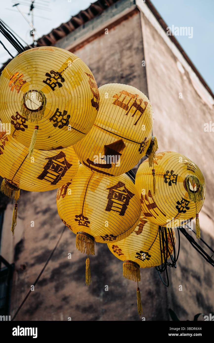 Scène thaïlandaise urbaine avec des lanternes Khom Pha accrochées aux lignes électriques, mettant en valeur la culture thaïlandaise traditionnelle Banque D'Images