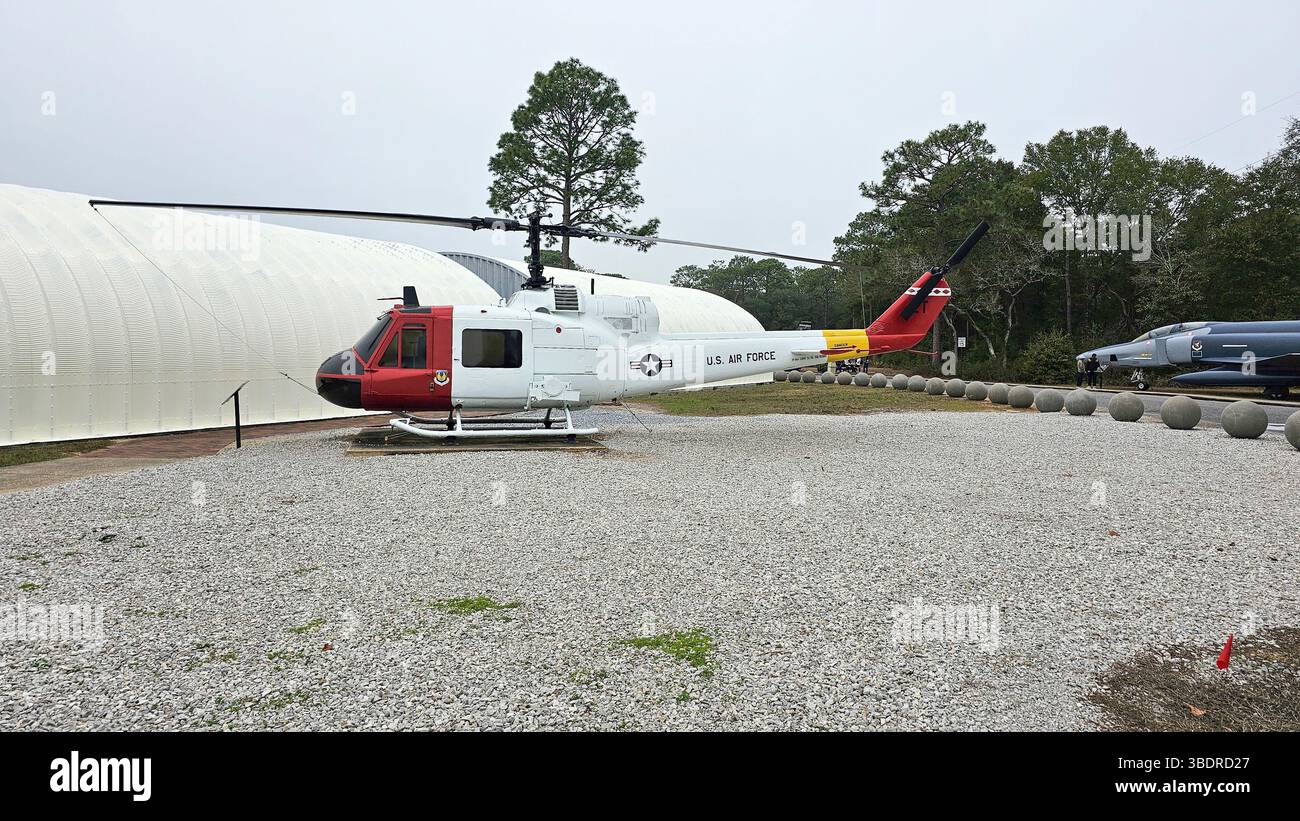 Eglin AFB, FL États-Unis - 12.27.2024 : hélicoptère vintage exposé à l'extérieur avec un design unique de queue rouge et jaune, et Gravel gris. Banque D'Images