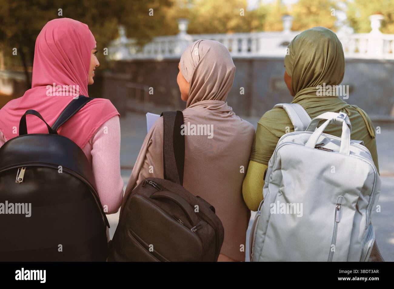Trois musulmanes avec sacs à dos Retour à l'appareil photo en extérieur Banque D'Images