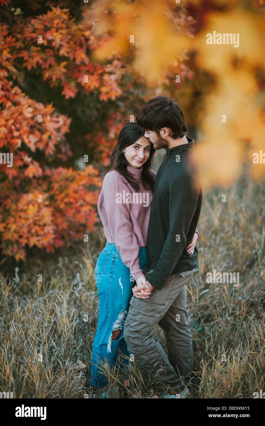 Couple aimant profite de moment d'automne paisible par des arbres colorés Banque D'Images