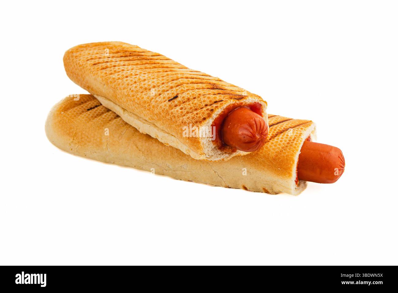 Deux hot dogs fraîchement cuits nichés dans des petits pains grillés sont prêts à être dégustés. Parfait pour un repas décontracté ou une réunion à tout moment de la journée. Banque D'Images