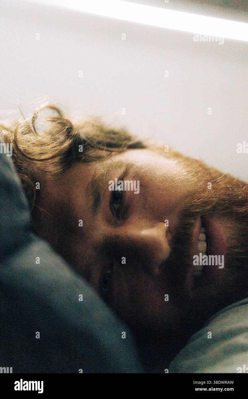 Portrait de l'homme se relaxant sur le lit à la maison, gros plan Banque D'Images