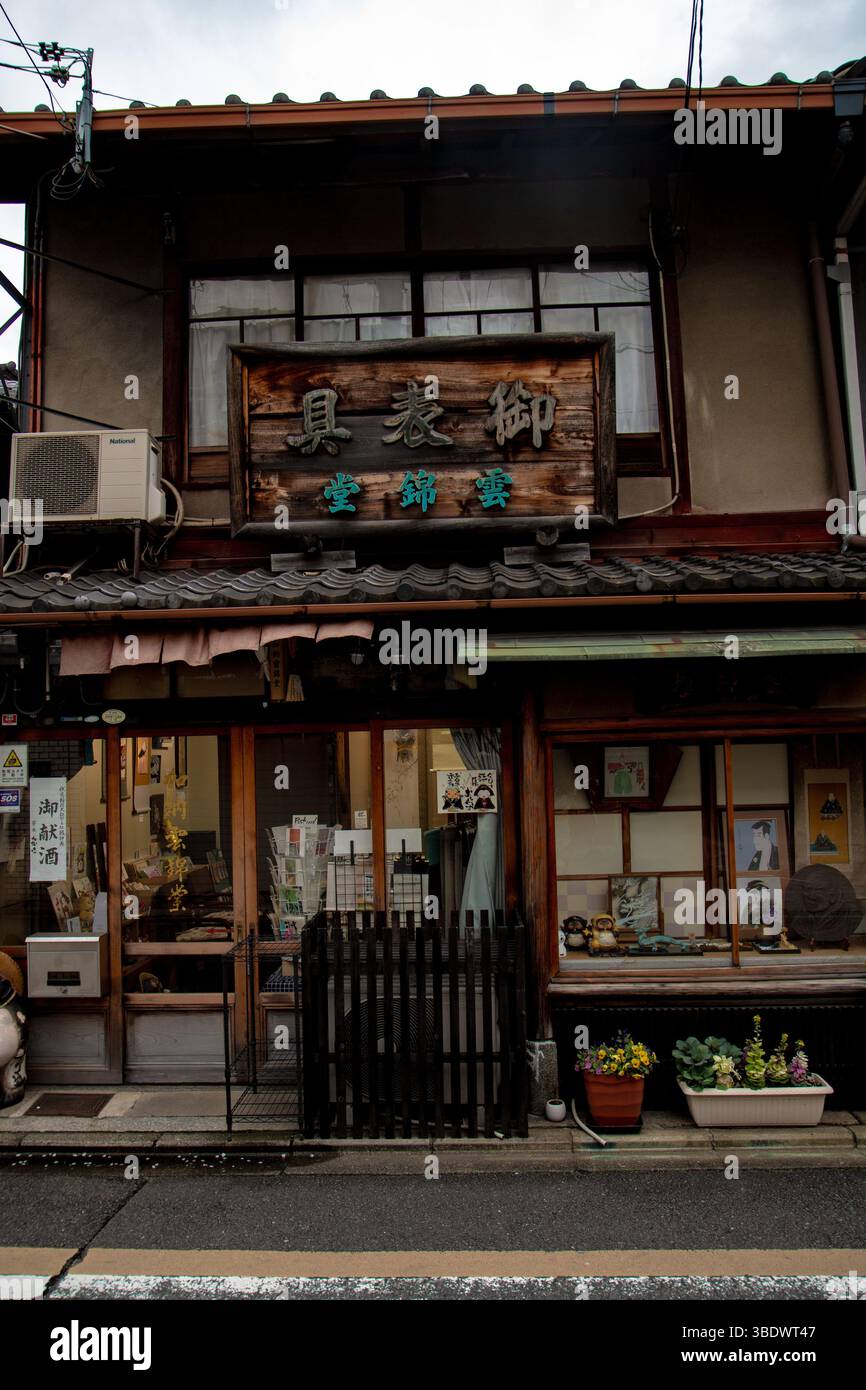 Vitrine traditionnelle de Kyoto avec panneaux en bois et vitrine présentant l'artisanat local sous la lumière du jour douce Banque D'Images