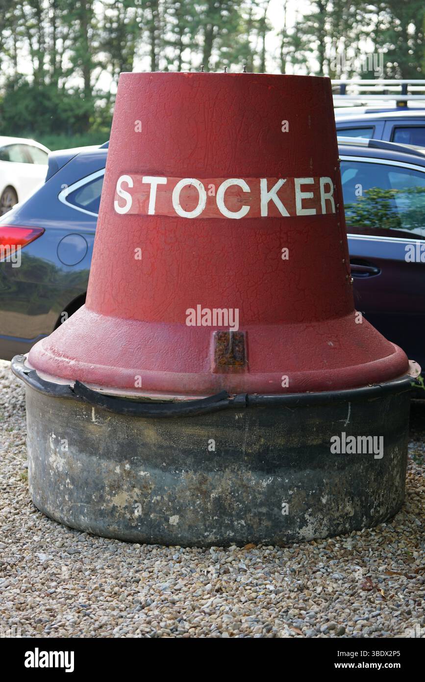 Grande bouée rouge avec inscription blanche stocker dans le parking extérieur. Itchenor, Royaume-Uni Banque D'Images