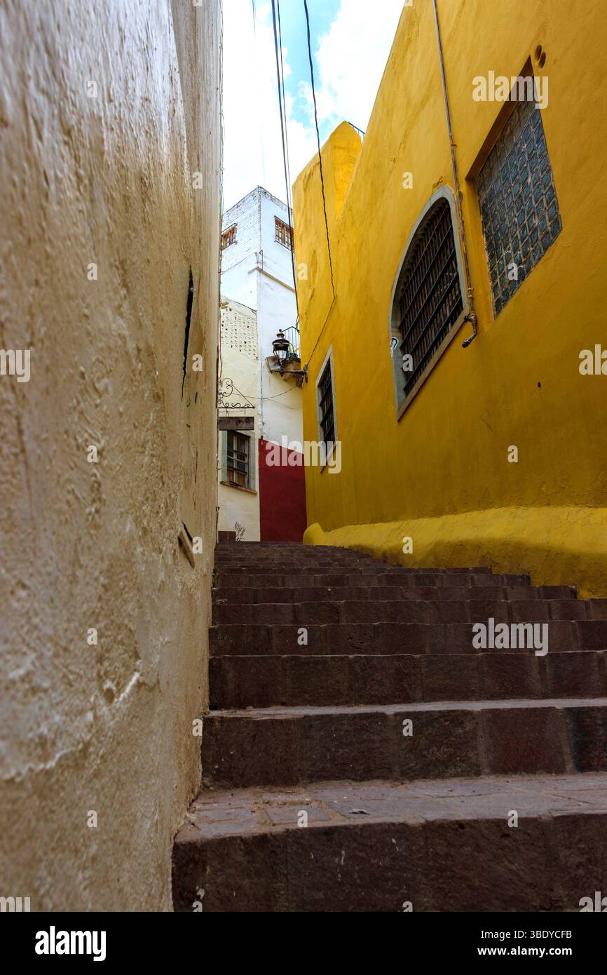 Guanajuato City, Mexique - 30 mai 2016 : une ruelle étroite avec des marches en pierre menant entre des bâtiments colorés. Banque D'Images