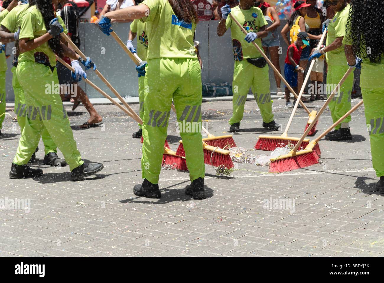 Salvador, Bahia, Brésil - 01 mars 2025 : plusieurs membres du personnel de nettoyage sont vus en train de nettoyer la rue après le passage d'un trio électrique pendant le carnaval Banque D'Images