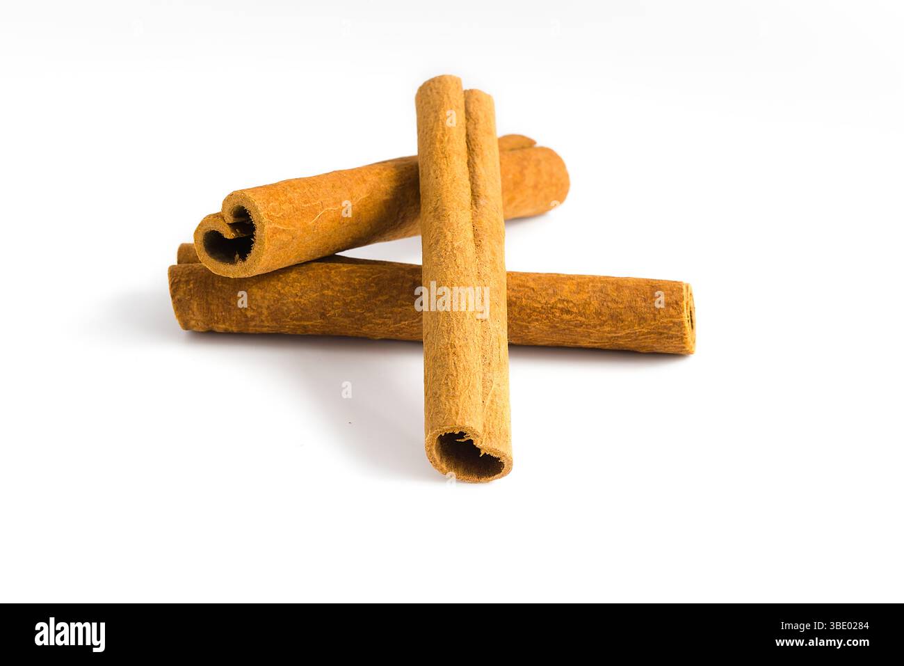 Collection de fragments d'écorce de cannelle sur un fond blanc, capturant leur beauté naturelle, texture grossière et caractéristiques d'épices, parfait pour culi Banque D'Images