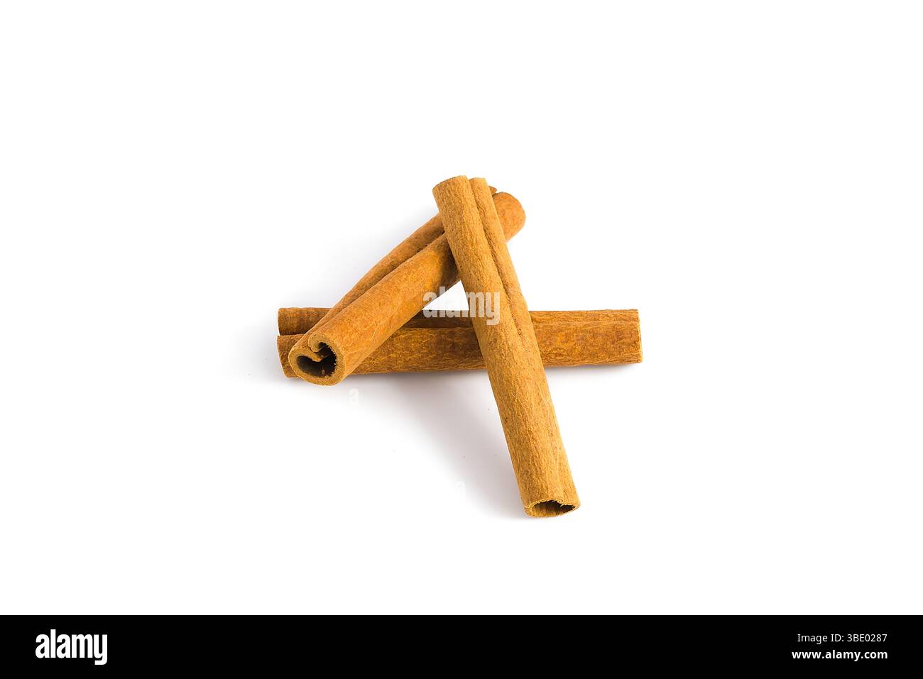 Fragments d'écorce de cannelle soigneusement disposés sur une surface blanche, en se concentrant sur leur texture grossière, leurs tons chauds et leurs formes naturelles, idéales pour la nourriture et les plantes Banque D'Images