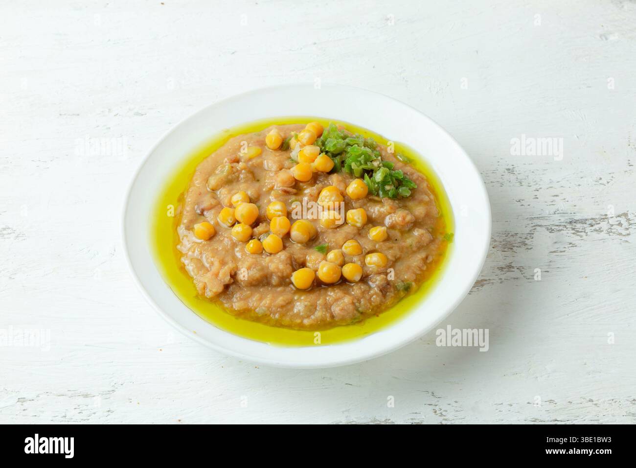 Bol de faute avec de l'huile d'olive sur un fond blanc - plat de petit déjeuner arabe traditionnel Banque D'Images