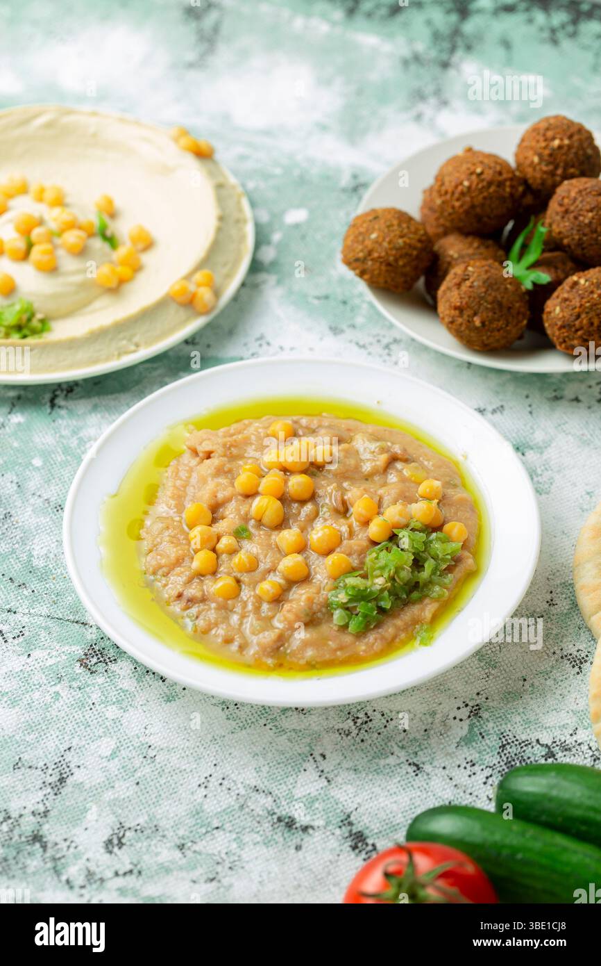 Petit-déjeuner arabe de style égyptien avec un bol copieux de fous, garni d'huile d'olive et de garnitures Banque D'Images