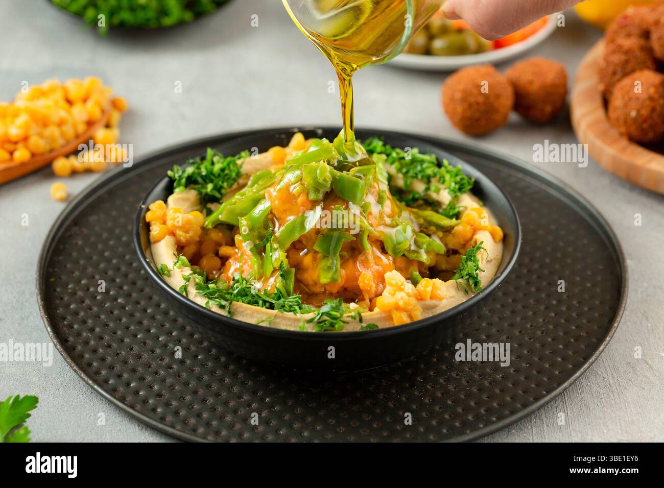 Fèves de Fava avec houmous, surmontées d'huile d'olive – assiette de petit déjeuner arabe traditionnelle. Banque D'Images