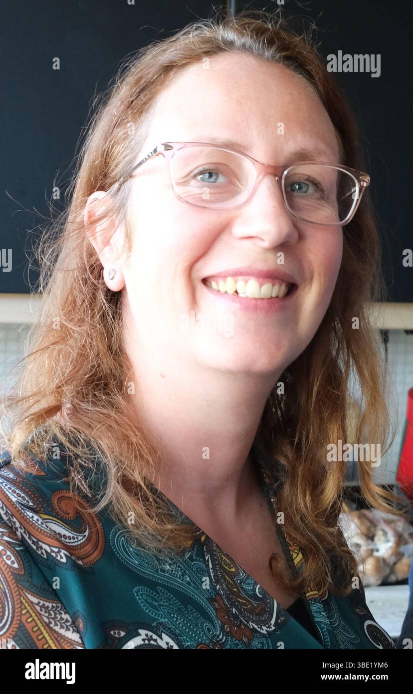 Heureuse femme hollandaise de 36 avec des lunettes. Elle porte un maquillage robuste et a un visage ouvert. Banque D'Images