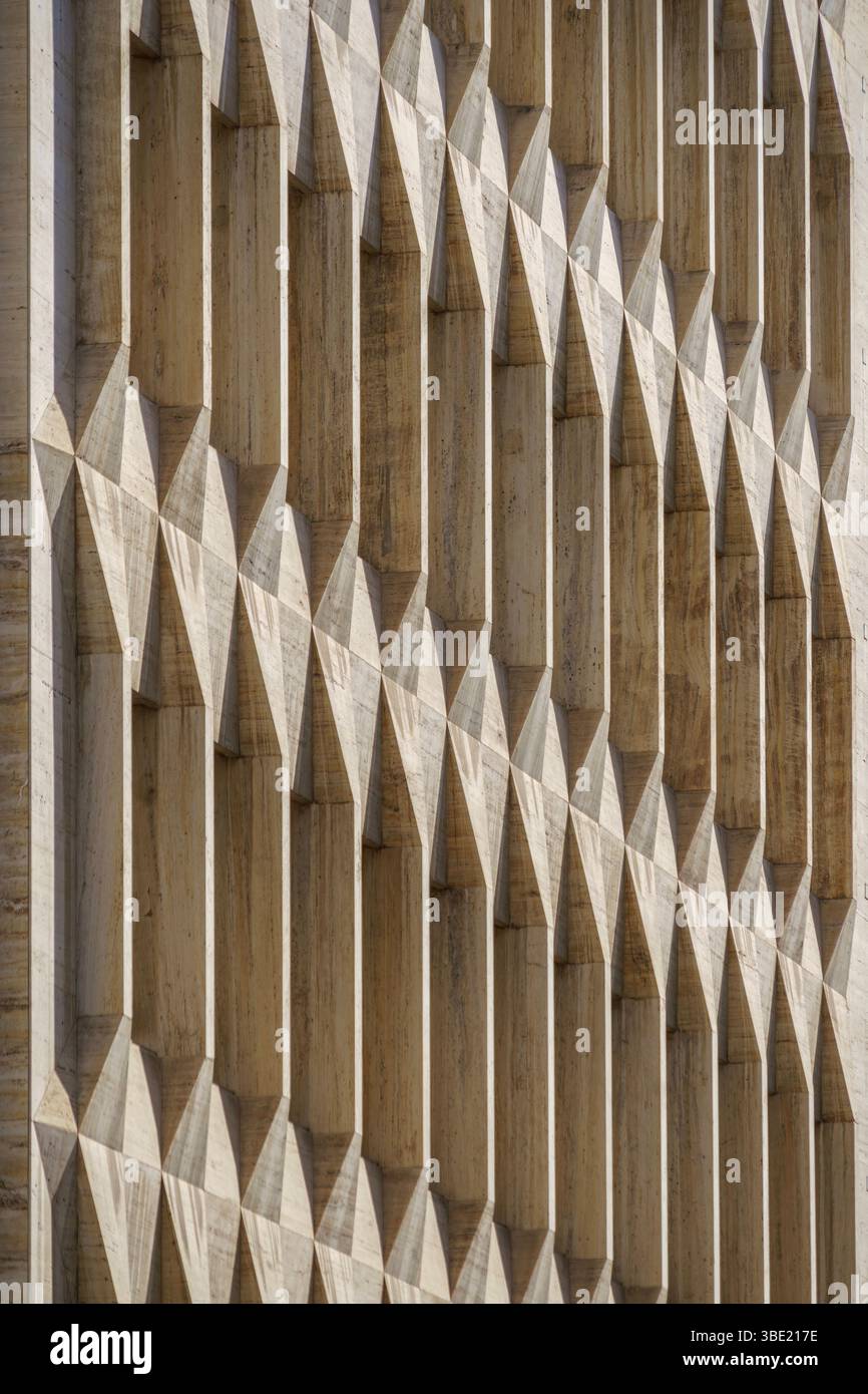 Façade géométrique en béton avec détails architecturaux répétitifs et ombres fortes. Extérieur du bâtiment moderne, design brutaliste, structure urbaine, abstr Banque D'Images