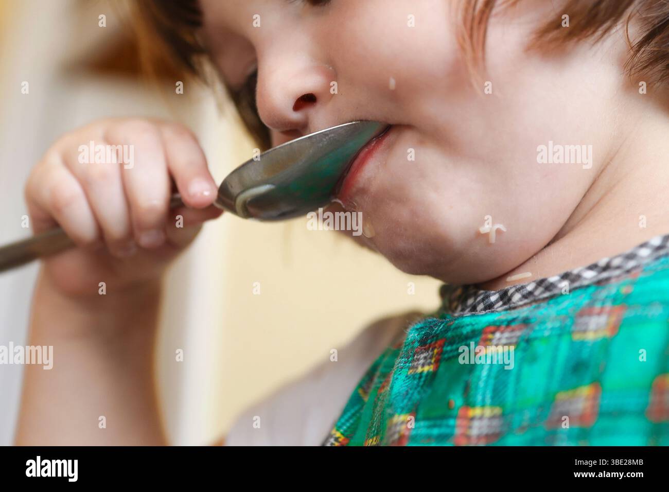 Un petit enfant apprend à manger de la soupe tout seul. Banque D'Images