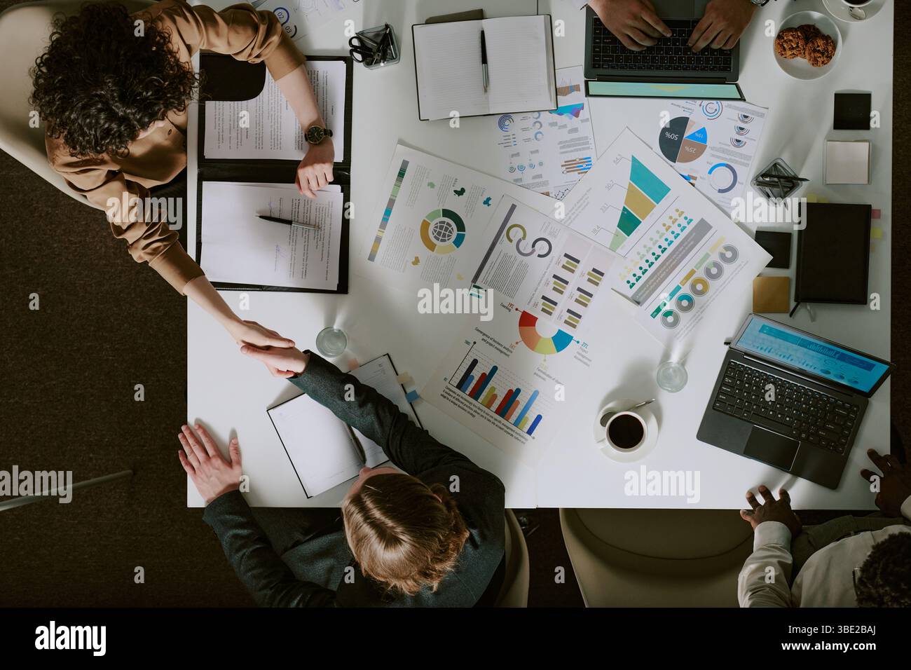 Rencontrer divers membres de l'équipe pour analyser les données de l'entreprise et discuter des stratégies de croissance de l'entreprise. Divers graphiques, documents et périphériques sur tabl Banque D'Images
