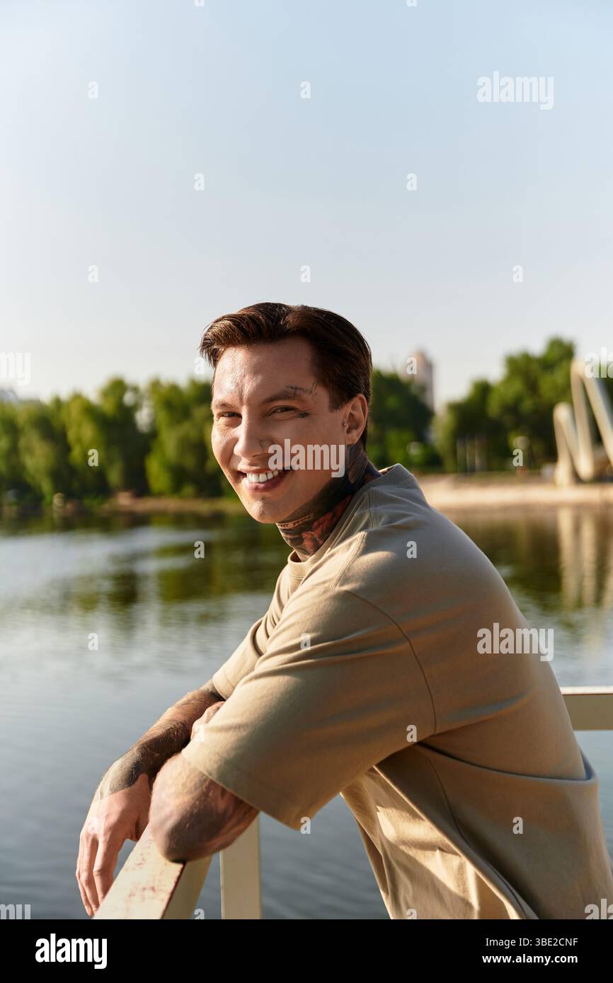 Un charmant jeune homme prend une promenade détendue le long d'une voie navigable pittoresque, souriant joyeusement. Banque D'Images