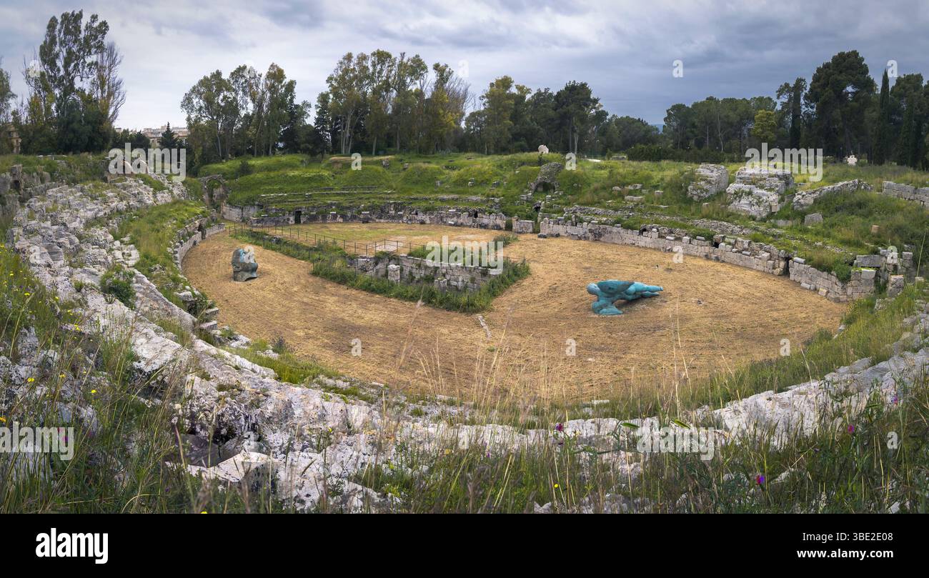 Les visiteurs explorent l'ancien amphithéâtre romain de Syracuse, où la nature rencontre l'histoire dans une beauté grandiose et luxuriante, Sicile, Italie Banque D'Images