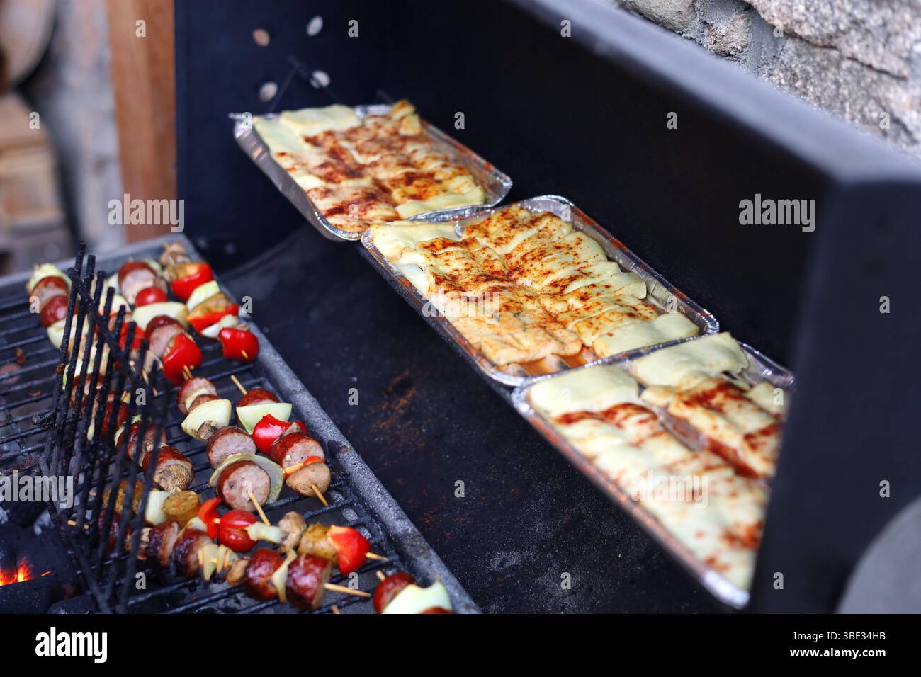 Fromage grillé et brochettes colorées grillant sur la grande grille métallique Banque D'Images