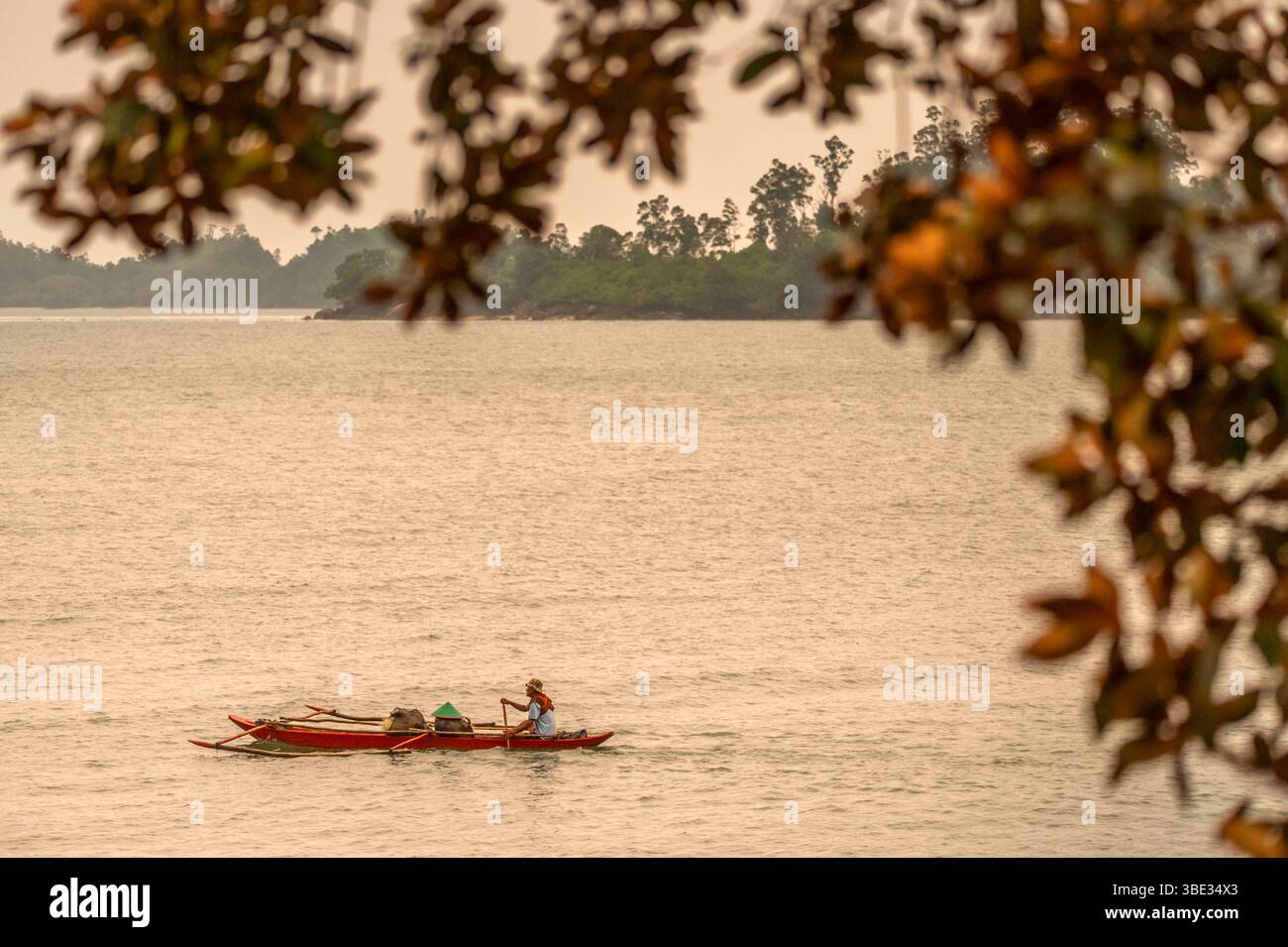 Indonésie, île de Sumatra, Pesisir Selatan, village de Sungai Pinang, pêcheur sur sa pirogue au coucher du soleil Banque D'Images