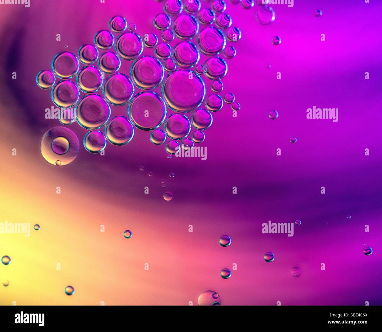 Bulles d'huile flottant sur l'eau avec un fond astract coloré Banque D'Images