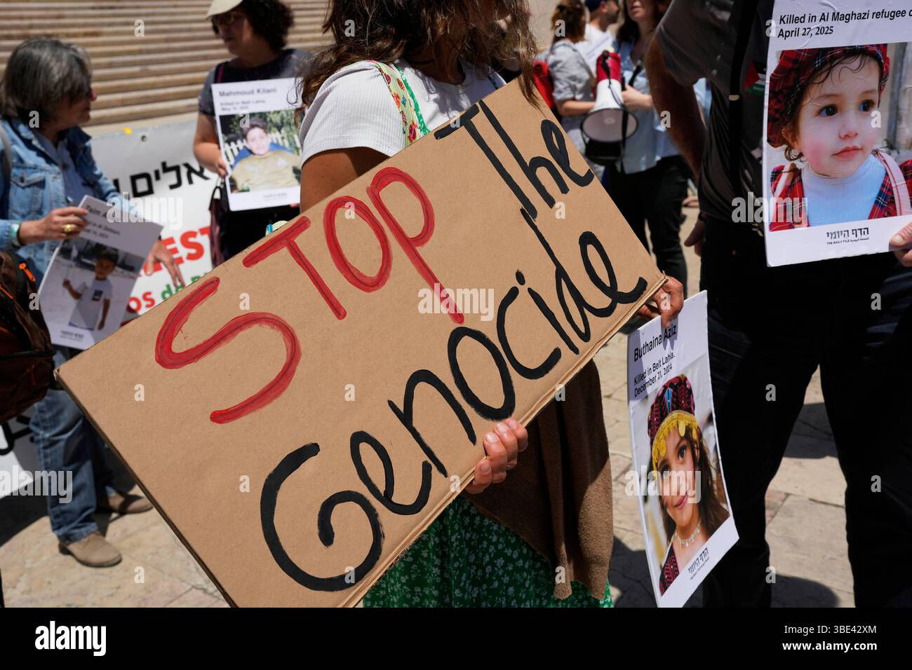 Protestors hold pictures of Palestinian children killed in Gaza during a demonstration organized by Israeli citizens demanding action from the European Union against the government of Israel to stop the war, outside the Portuguese parliament in Lisbon, Tuesday, May 27, 2025. (AP Photo/Armando Franca) Banque D'Images