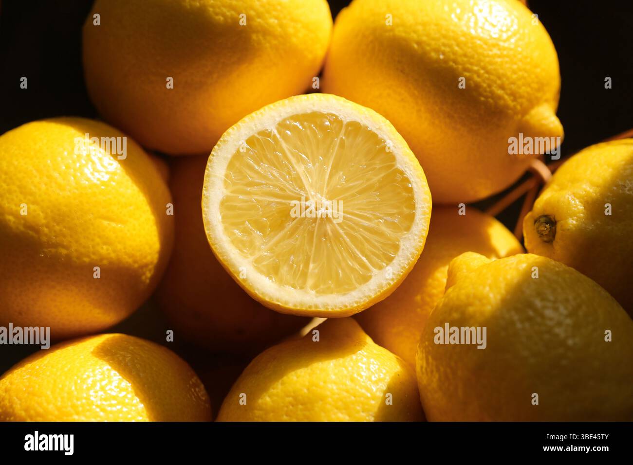 Citrons entiers baignés de soleil. Agrumes jaune vif avec des ombres naturelles. Produits biologiques frais. Arôme tropical et ingrédient sain. Banque D'Images