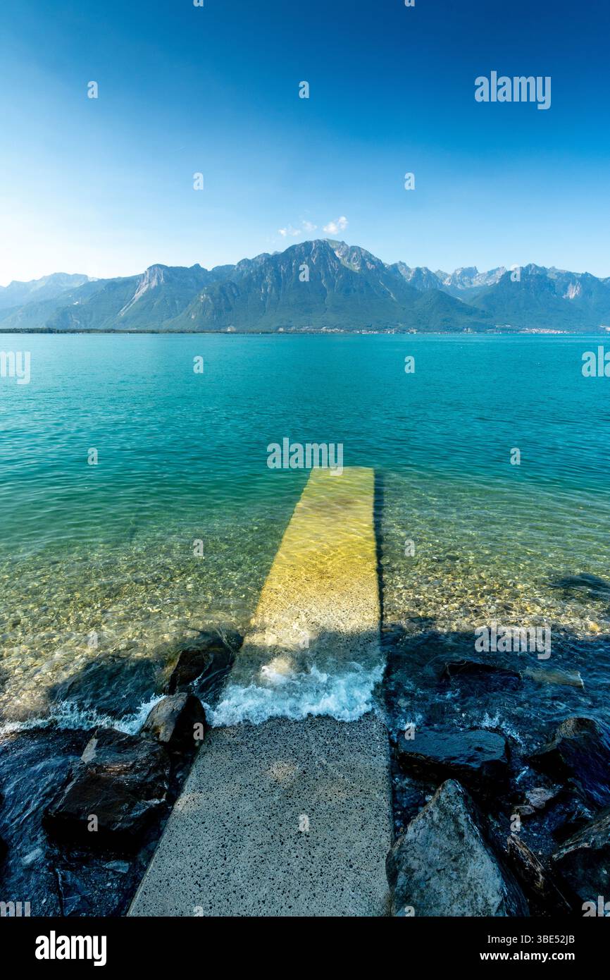 Montreux. Un quai s'étend dans les eaux tranquilles du lac Léman, entouré de superbes sommets montagneux. Suisse Banque D'Images