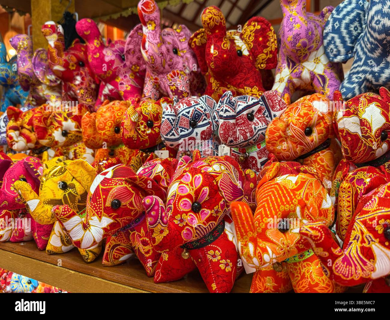 Exposition vibrante de jouets en peluche éléphants aux motifs complexes, mettant en vedette des motifs et des couleurs thaïlandais traditionnels. Souvenirs parfaits qui capturent le culte thaïlandais Banque D'Images