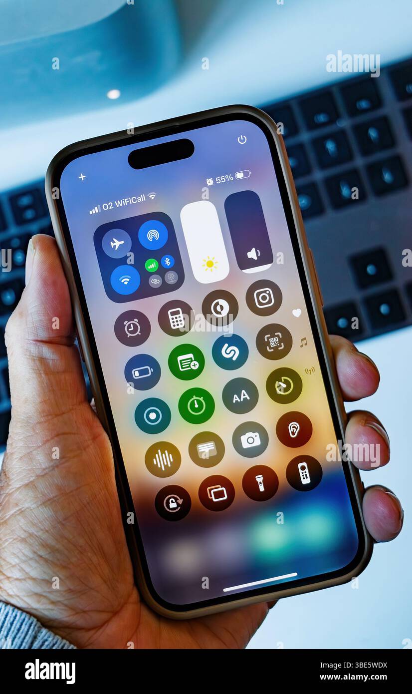 Gros plan de la main tenant l'écran du smartphone Apple iphone 14 pro montrant les icônes des applications dans l'interface du centre de contrôle - centre de contrôle Banque D'Images