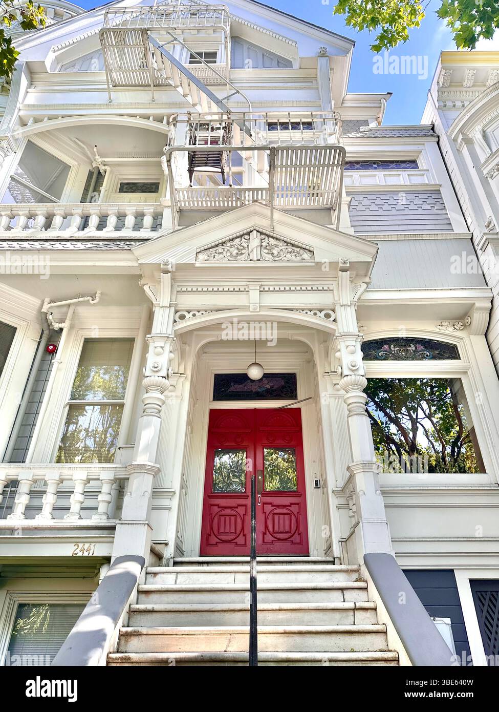 Maisons dans San Francisco Californie Victoria Ornate double Door Mansion Iron Fence Garden Trees Bush Vines Dollhouse Wooden - Image de stock capturée avec un smartphone