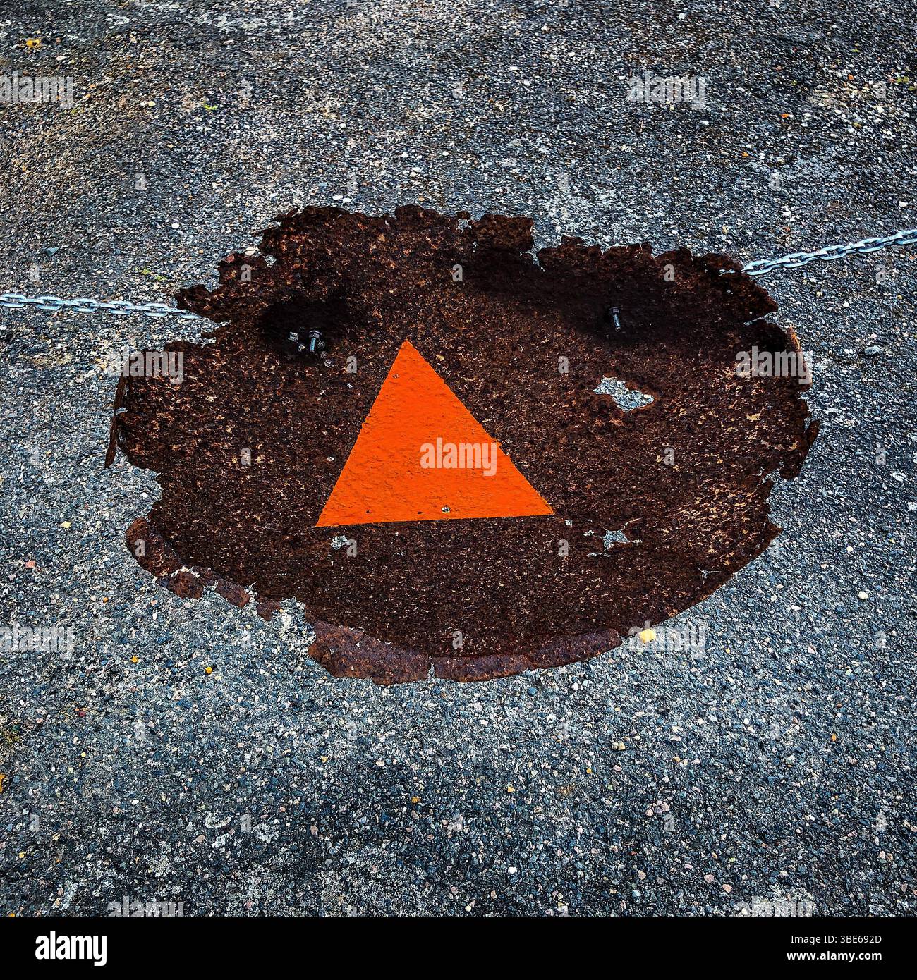 Triangle rouge peint à la main sur morceau de métal rouillé sur une chaîne agissant comme un panneau d'arrêt / d'interdiction d'entrée - France. Banque D'Images