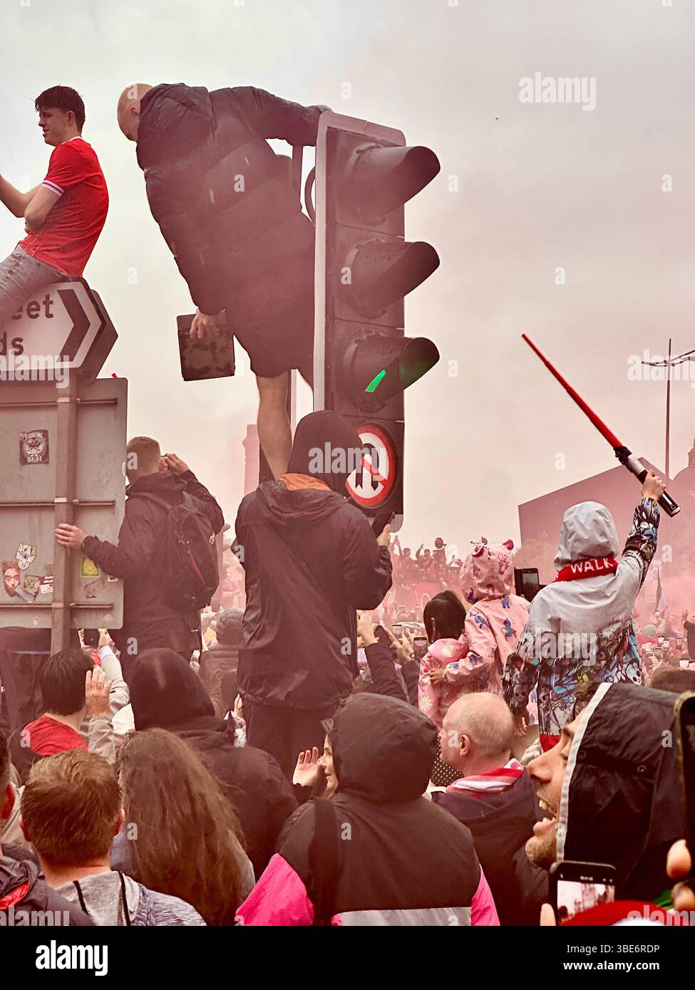Les fans applaudissent alors que le bus de Liverpool approche pendant la parade de la victoire ; enfant lève le sabre laser, Strand Street, Liverpool, lundi, 26 mai 2025. - Image de stock capturée avec un smartphone