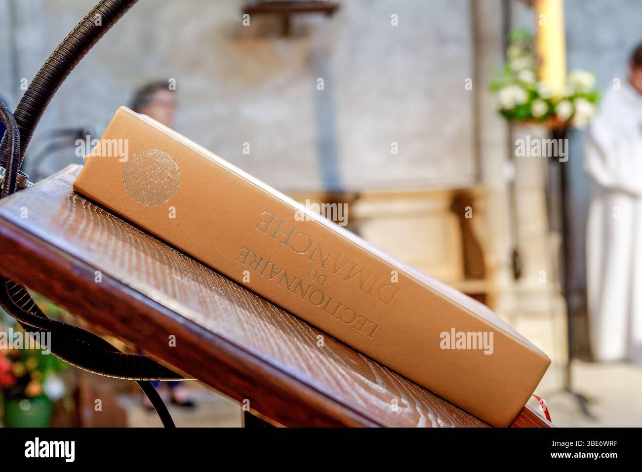 Un lectionnaire fermé, le livre liturgique utilisé pour les lectures scripturales pendant la messe catholique, reposant sur un pupitre à l'intérieur d'une église traditionnelle. Un sacré Banque D'Images