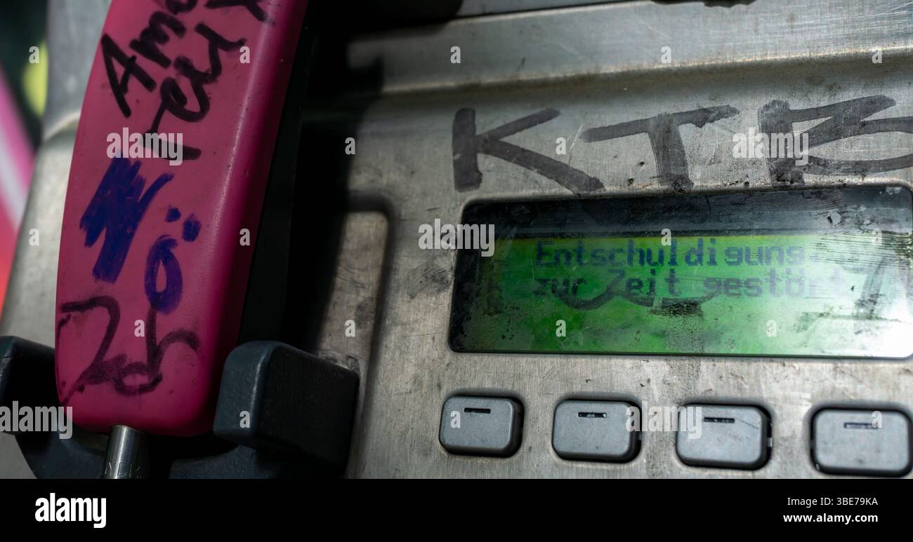Vieux téléphone public de Telekom à Berlin montrant "désolé, actuellement hors service" sur son écran, lourdement usé et vandalisé. Banque D'Images