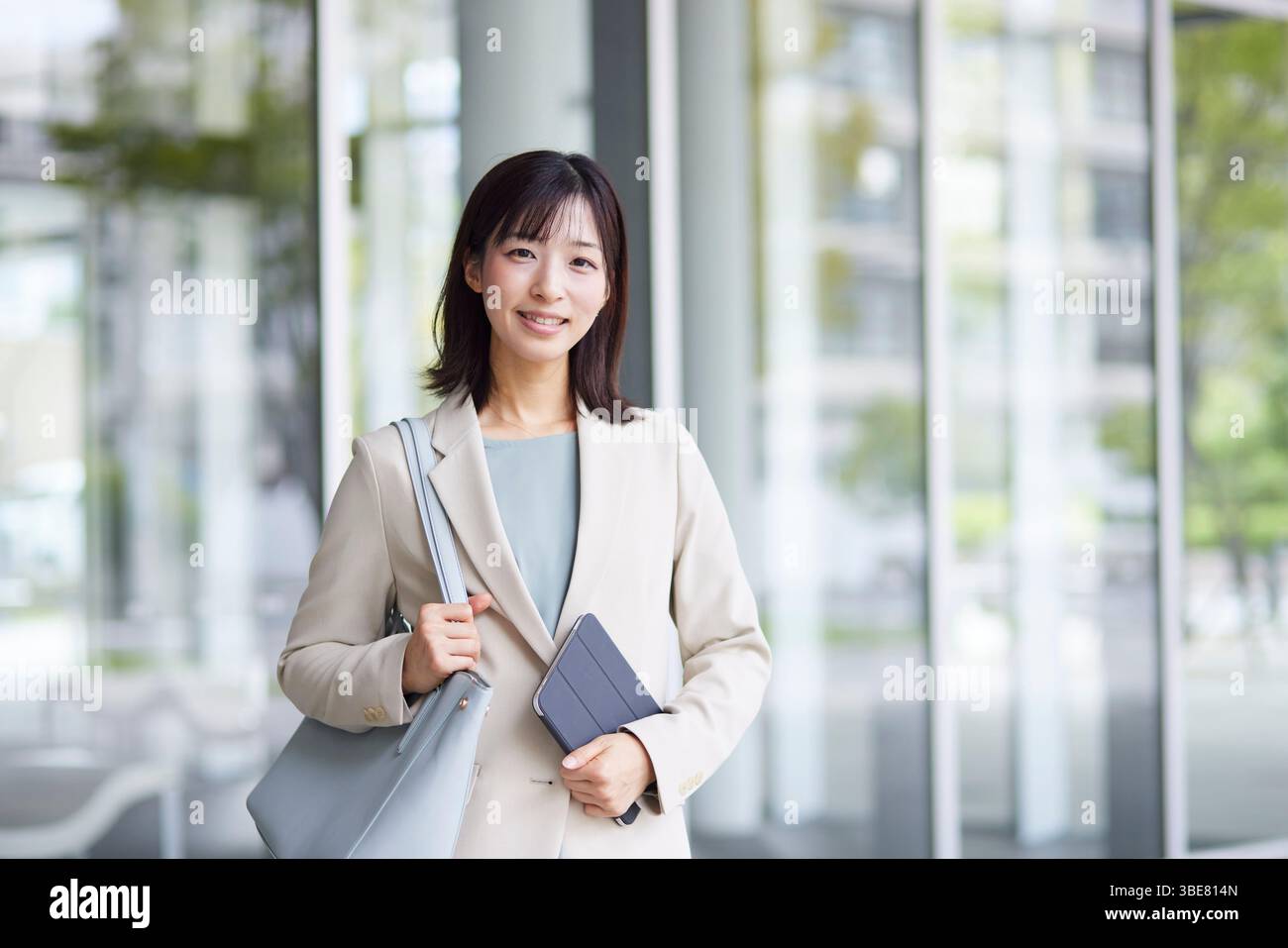 Femme d'affaires japonaise souriante en costume Banque D'Images