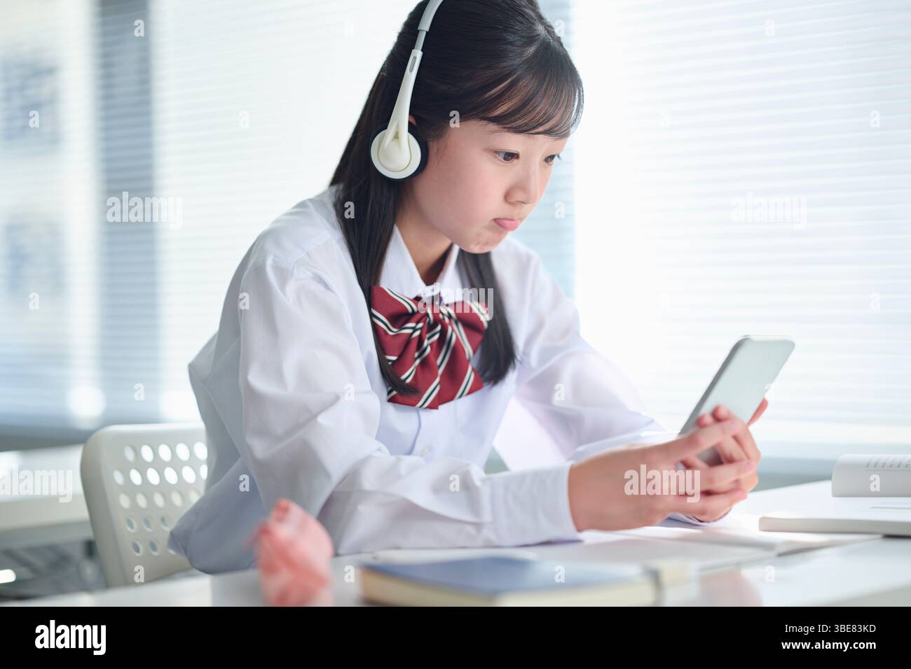 Des filles du secondaire suivent des cours sur smartphones Banque D'Images