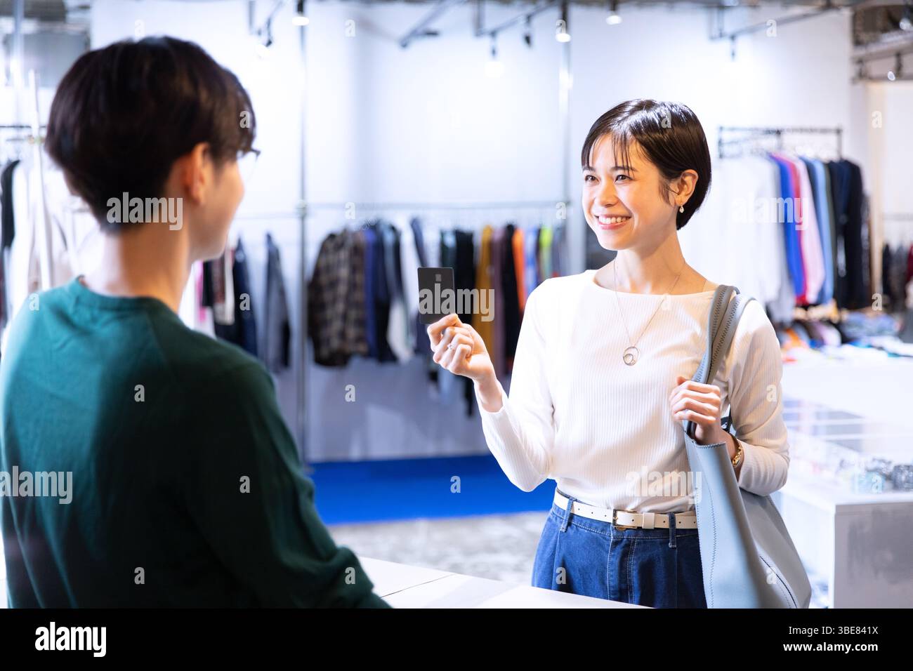 Femme et assistant de magasin tenant la carte de crédit Banque D'Images