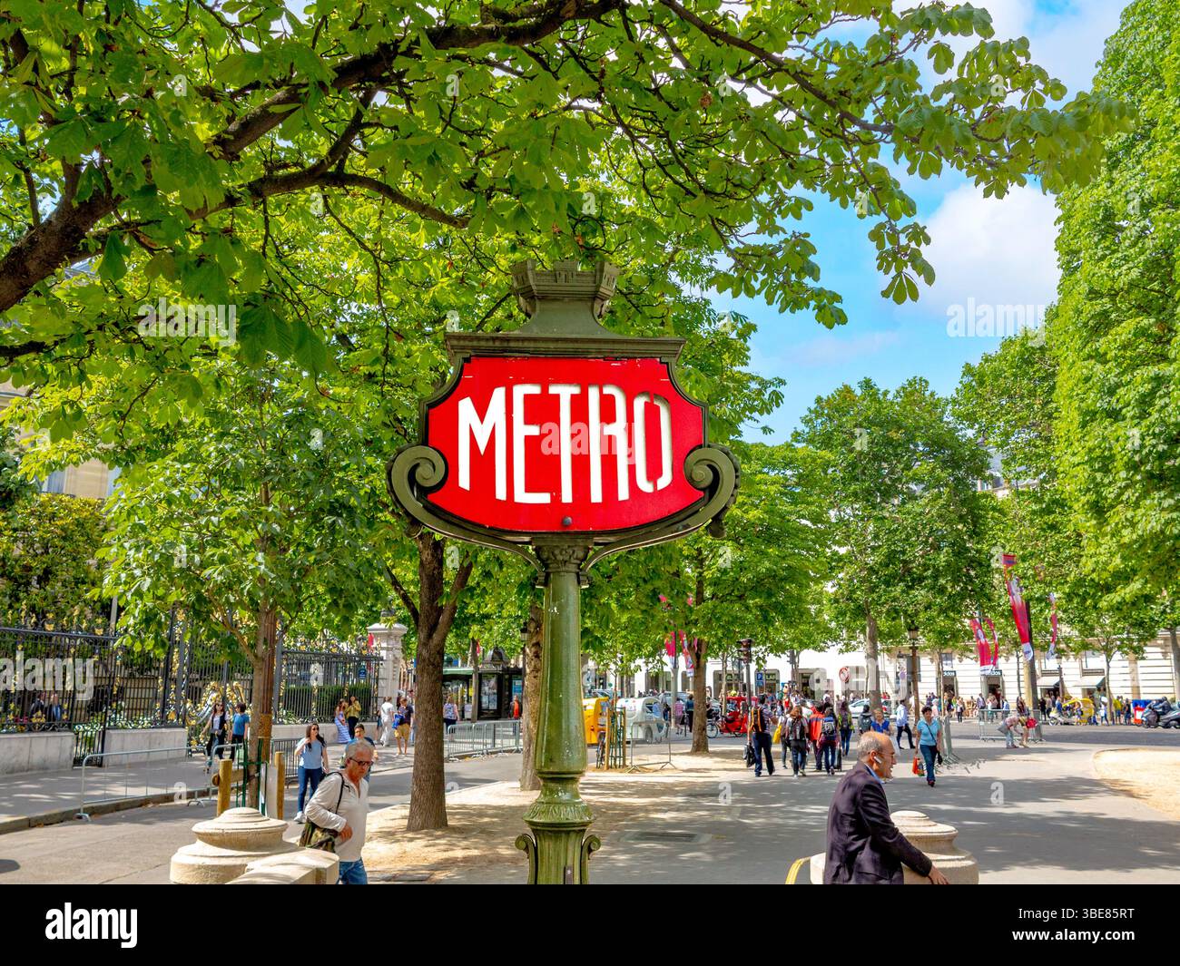 Paris, France - 12 juin 2015 : les gens profitent d'une journée d'été aux champs-élysées sous l'allée des arbres avec un panneau historique Art nouveau Metro en foregro Banque D'Images