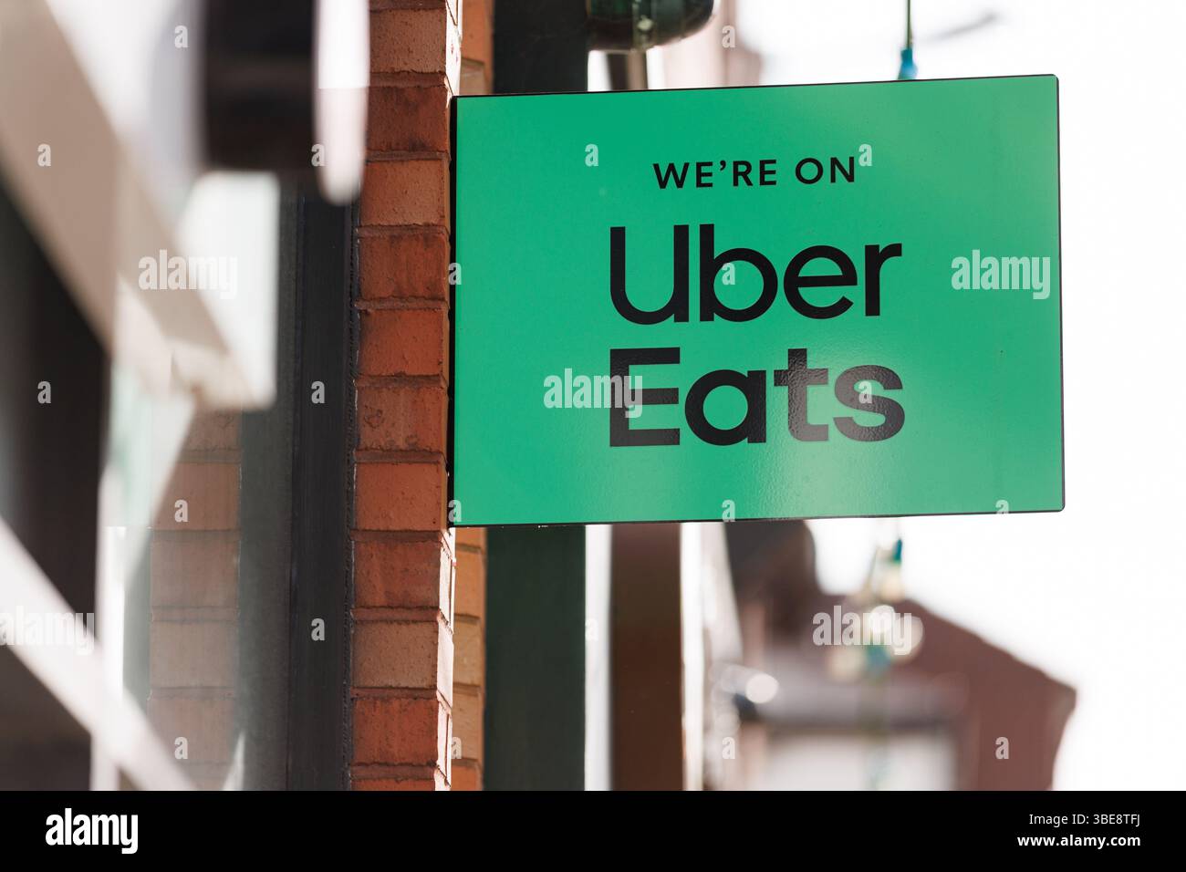 Un point de vente d'aliments annonçant qu'Uber mange via un panneau à l'extérieur du magasin. Logo vert Uber Eats avec la marque « We're on Uber Eats ». Uber Eats Royaume-Uni, Uber Eats Royaume-Uni, application de livraison Banque D'Images