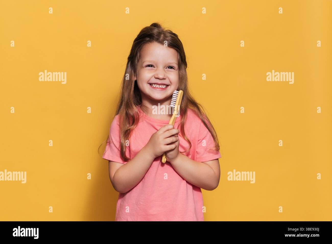 Une fille heureuse tient une brosse à dents dans ses mains. Un tir isolé. Odontologie pédiatrique Banque D'Images