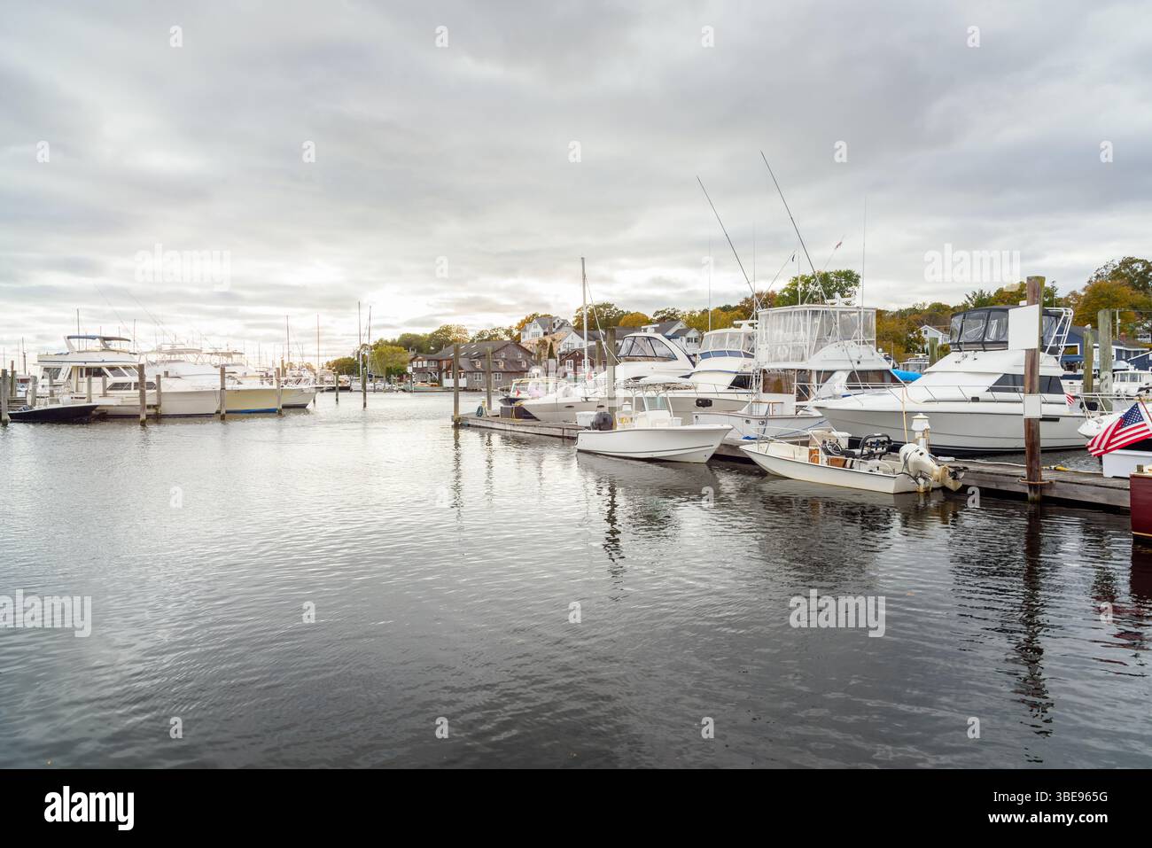 Yachts amarrés à des jetées dans une marina par un jour nuageux d'automne Banque D'Images
