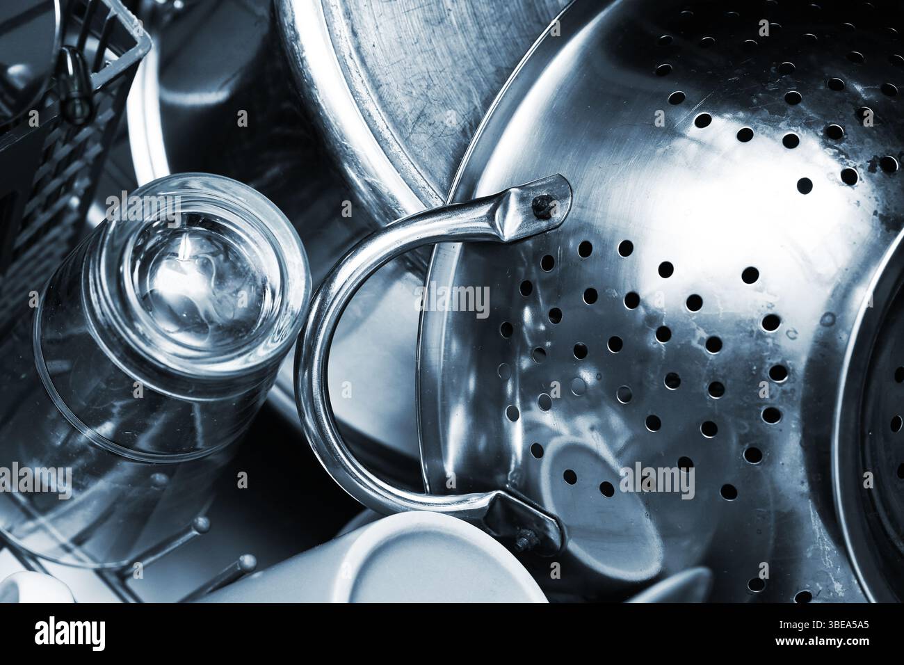 Ustensiles de cuisine en métal dans l'évier. Vaisselle lavée après cuisson. Pots et verrerie en acier inoxydable. Scène de nettoyage domestique. Détail lave-vaisselle. Banque D'Images