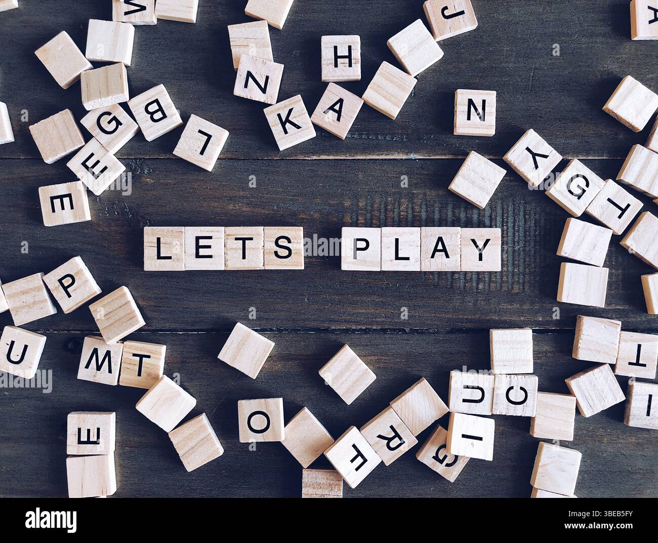 Jeu de plateau de carreaux de lettre sur table en bois avec mots Lets Play Banque D'Images