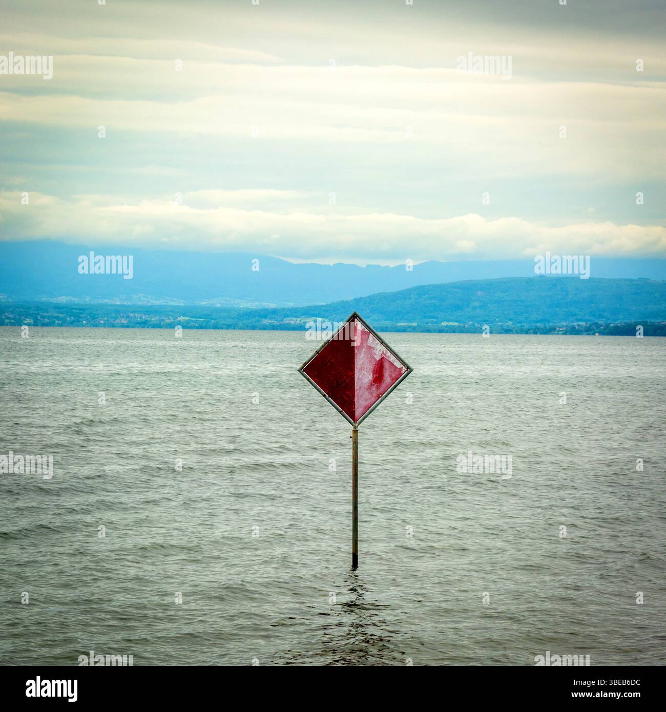 Un panneau d'information rouge proéminent s'élève au-dessus de l'eau du lac Léman, indiquant la sécurité ou la navigation. Suisse Banque D'Images