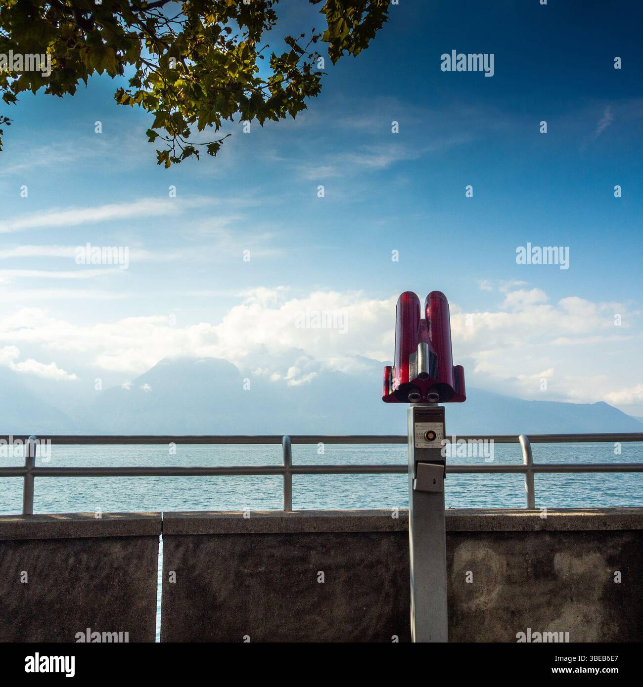 Un télescope se dresse sur la passerelle au bord du lac à Vevey, en Suisse, surplombant le lac Léman. Suisse Banque D'Images