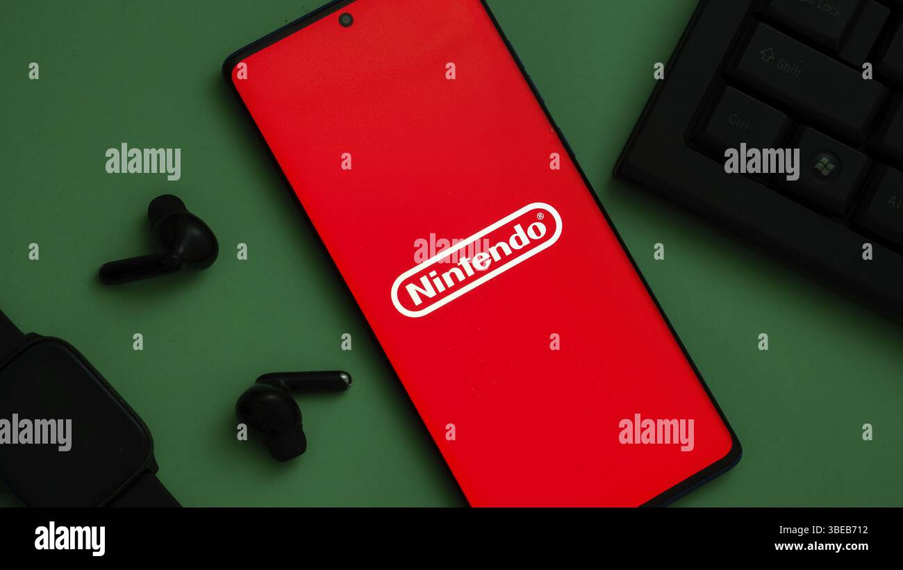 Logo Nintendo sur un smartphone avec accessoires de jeu sur un écran rouge Banque D'Images