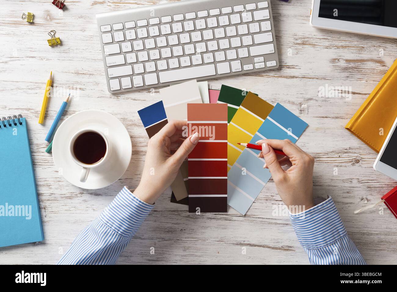 Concepteur Web choisissant des couleurs à partir de nuances au bureau en bois. Lieu de travail de bureau avec clavier d'ordinateur et tasse de café. Conception de l'interface utilisateur de mobi Banque D'Images