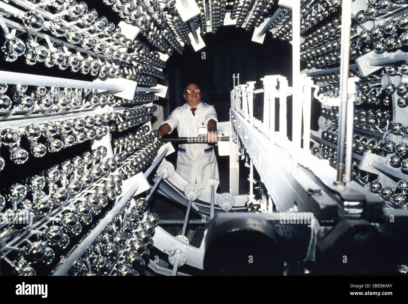 Un homme avec une machine à argenter les boules de Noël, pour décorer les arbres de Noël, Treorchy, pays de Galles, Royaume-Uni Banque D'Images