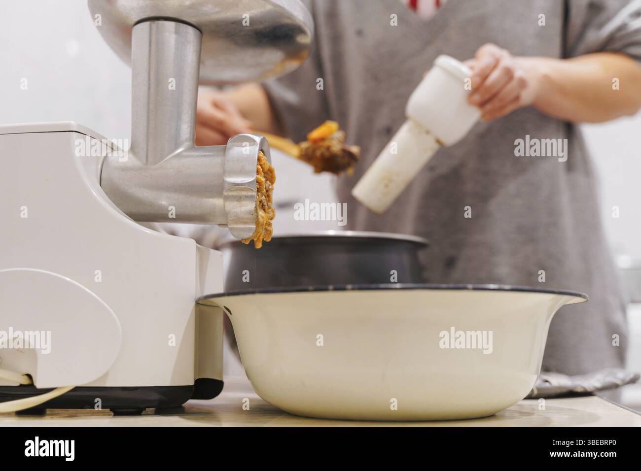 Hachoir à viande dans la cuisine à la maison. Photographie de style de vie. Préparation des aliments . Banque D'Images